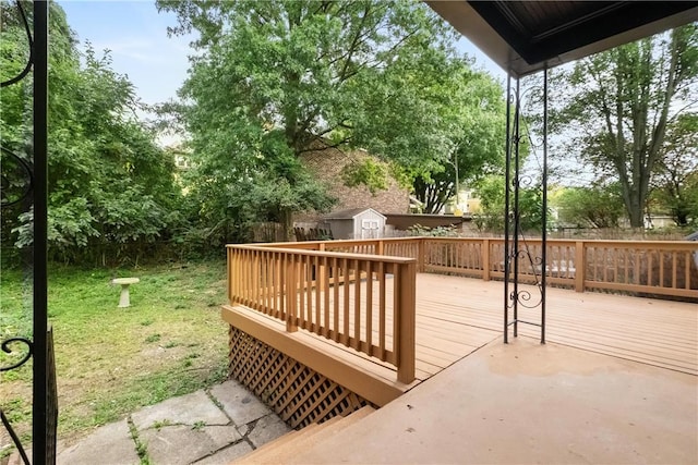 wooden deck featuring a storage shed and a lawn