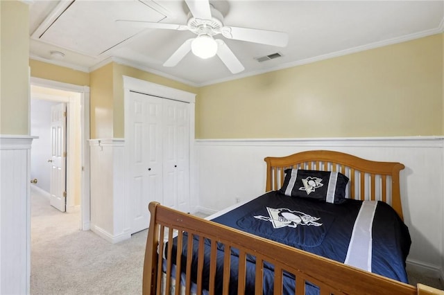 carpeted bedroom featuring a closet, ceiling fan, and ornamental molding