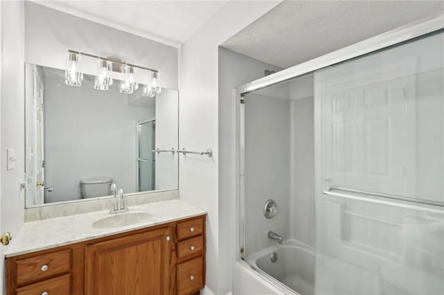 full bathroom featuring a textured ceiling, vanity, toilet, and bath / shower combo with glass door