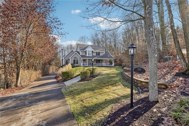 cape cod-style house featuring a porch and a front lawn