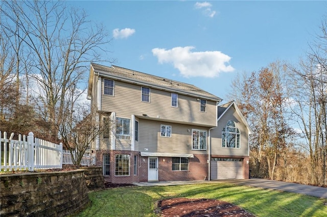 rear view of property with a garage and a yard