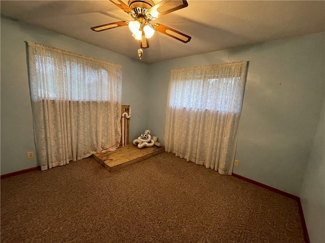 empty room featuring carpet flooring, ceiling fan, and a healthy amount of sunlight