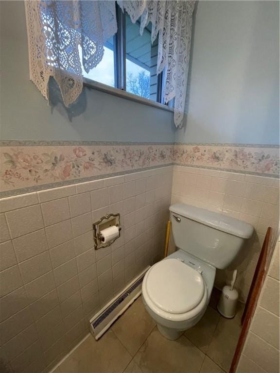 bathroom with tile patterned flooring, toilet, tile walls, and a baseboard heating unit