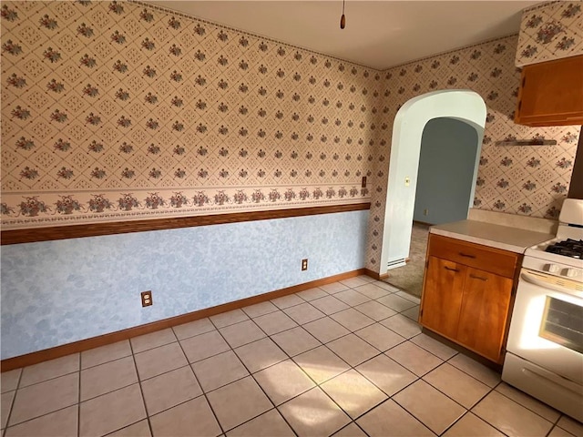 kitchen featuring light tile patterned flooring and white gas range oven