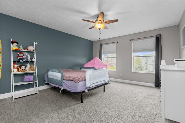 bedroom with carpet flooring, ceiling fan, and a textured ceiling