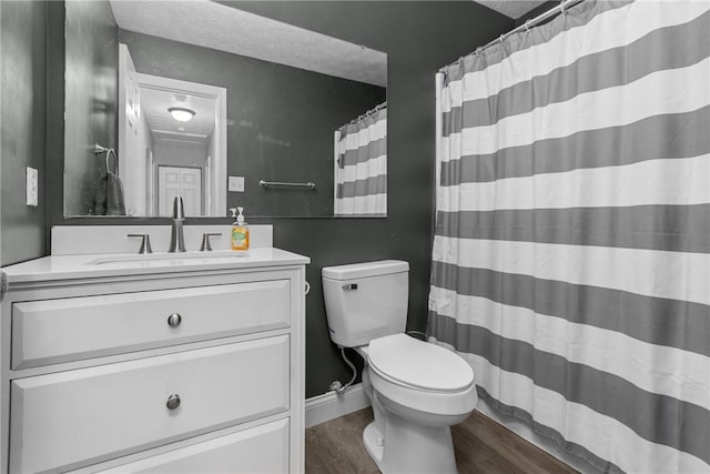 bathroom with a textured ceiling, vanity, hardwood / wood-style flooring, and toilet