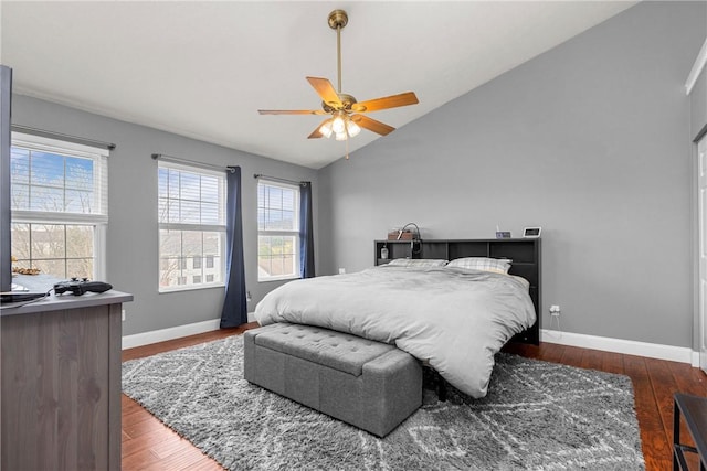 bedroom with dark hardwood / wood-style flooring, vaulted ceiling, and ceiling fan