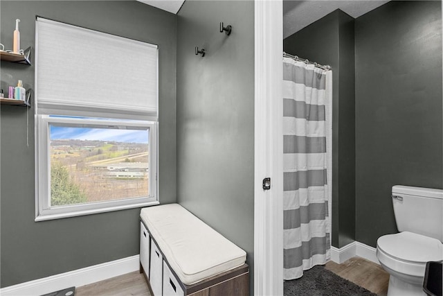 bathroom featuring hardwood / wood-style floors, toilet, and curtained shower