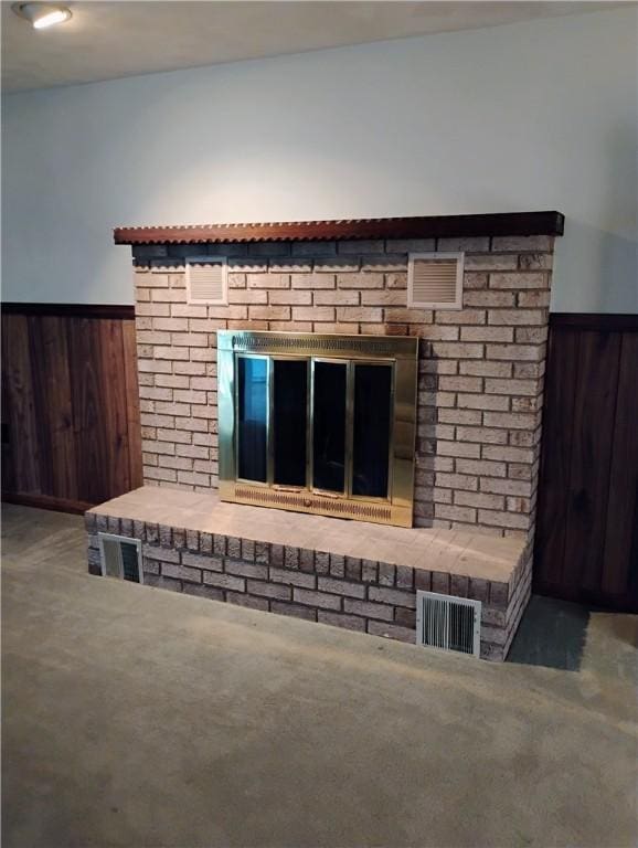 details featuring wooden walls and a brick fireplace