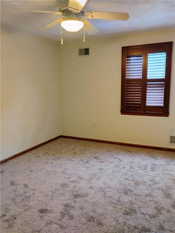 carpeted spare room featuring ceiling fan