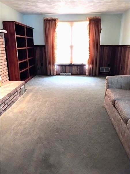 unfurnished living room featuring a fireplace and carpet floors