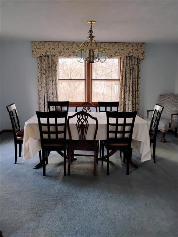 carpeted dining area with a chandelier