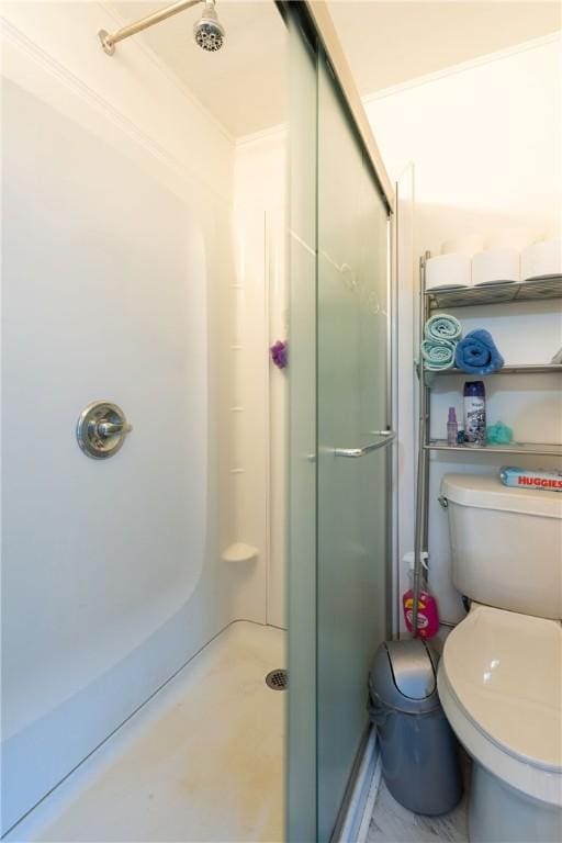 bathroom featuring toilet, an enclosed shower, and ornamental molding