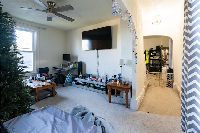 carpeted living room with ceiling fan