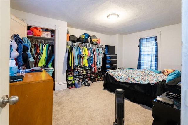 carpeted bedroom featuring a textured ceiling and a closet