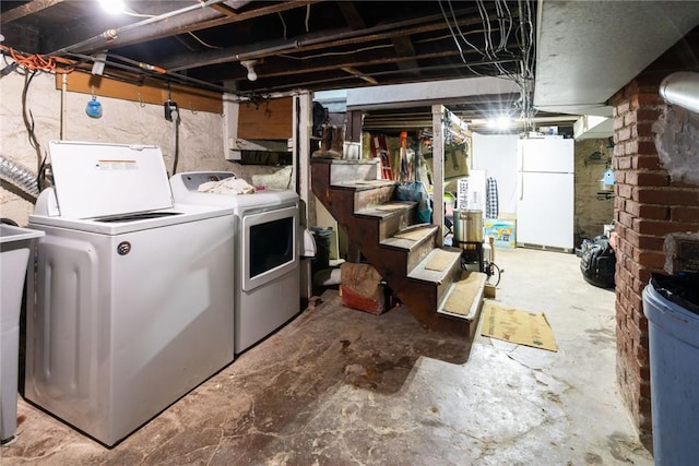 basement featuring independent washer and dryer and white fridge