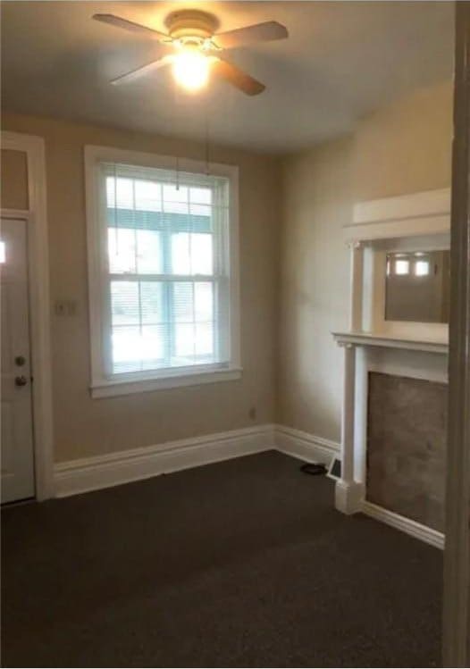 unfurnished living room featuring ceiling fan