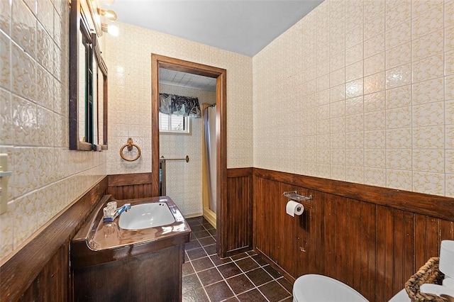 bathroom with tile patterned floors, wooden walls, vanity, and a shower with shower door