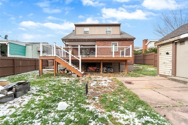 snow covered house featuring a deck and a patio area