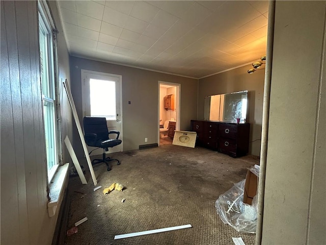 unfurnished bedroom with crown molding, wooden walls, and dark colored carpet