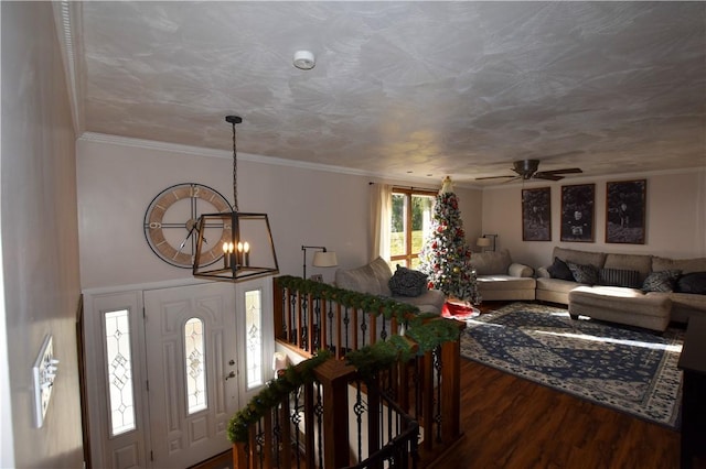 interior space featuring ceiling fan with notable chandelier, hardwood / wood-style flooring, and ornamental molding