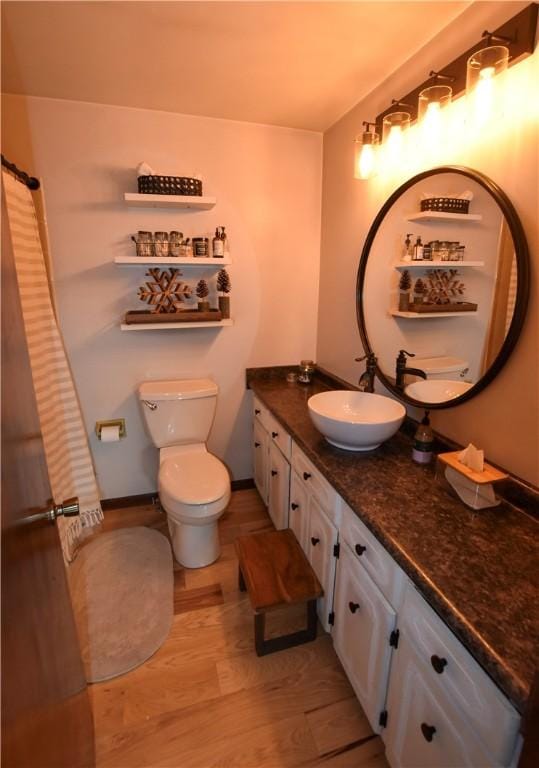 bathroom featuring toilet, vanity, and hardwood / wood-style flooring