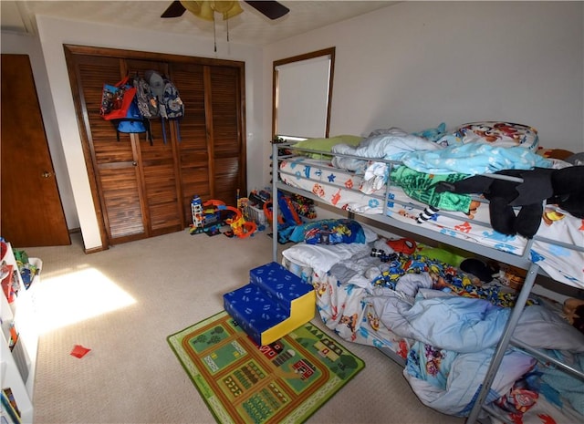 carpeted bedroom featuring ceiling fan and a closet