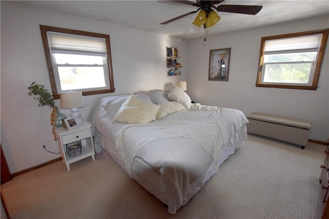 carpeted bedroom featuring ceiling fan and multiple windows