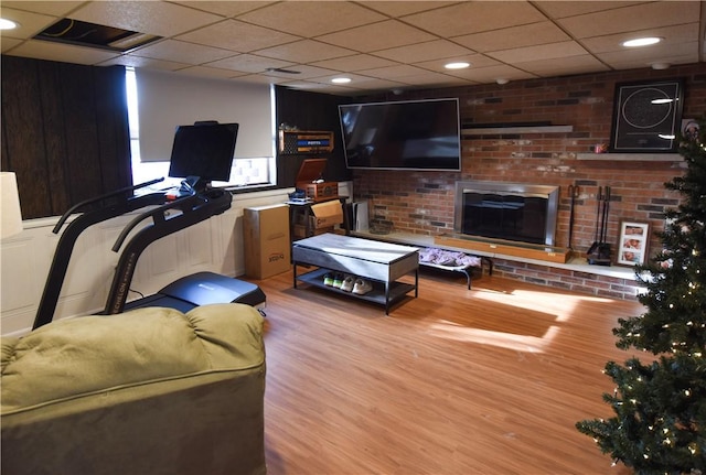 living room featuring a paneled ceiling and light hardwood / wood-style flooring