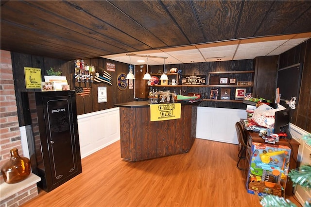 bar with dark brown cabinets, wooden walls, light hardwood / wood-style flooring, and wooden ceiling