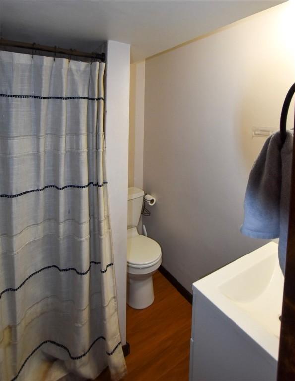 bathroom with hardwood / wood-style flooring and toilet