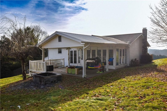 rear view of house featuring a lawn, a patio area, and french doors