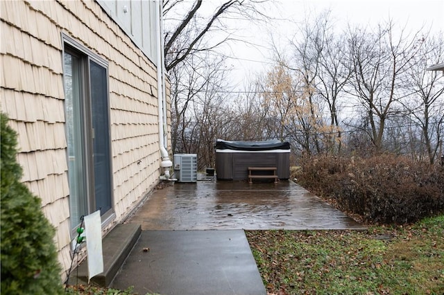 view of patio / terrace featuring central air condition unit and a hot tub