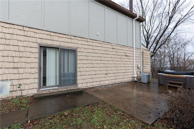 view of side of home with a patio area and central air condition unit