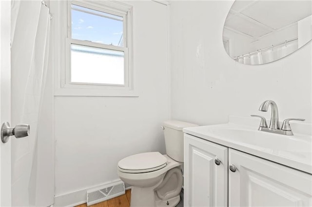 bathroom with hardwood / wood-style flooring, vanity, and toilet