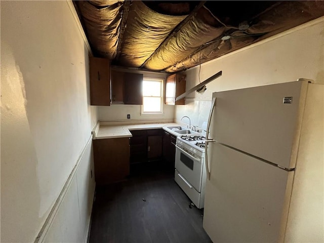 kitchen featuring dark hardwood / wood-style flooring, white appliances, and sink