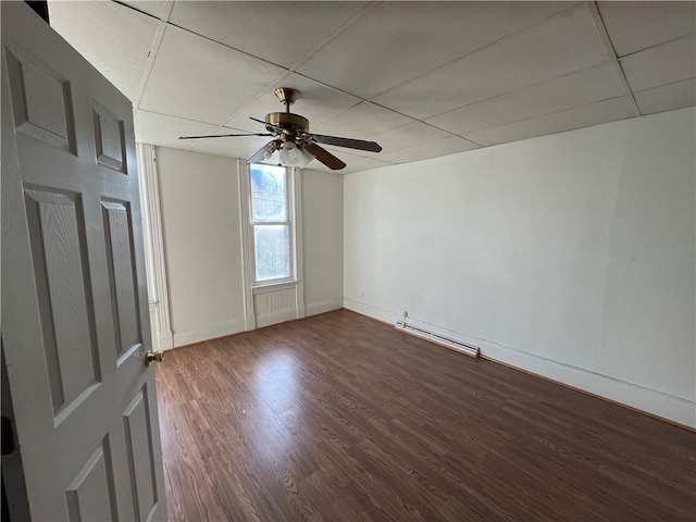 spare room with ceiling fan, wood-type flooring, and a baseboard heating unit