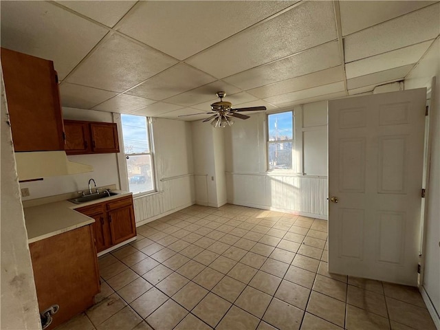 kitchen featuring light tile patterned floors, ceiling fan, a healthy amount of sunlight, and sink