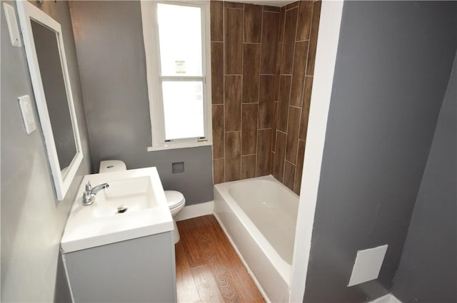 full bathroom featuring hardwood / wood-style floors, vanity, bathtub / shower combination, and toilet