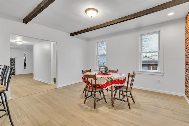 dining space with plenty of natural light, light hardwood / wood-style floors, and beam ceiling