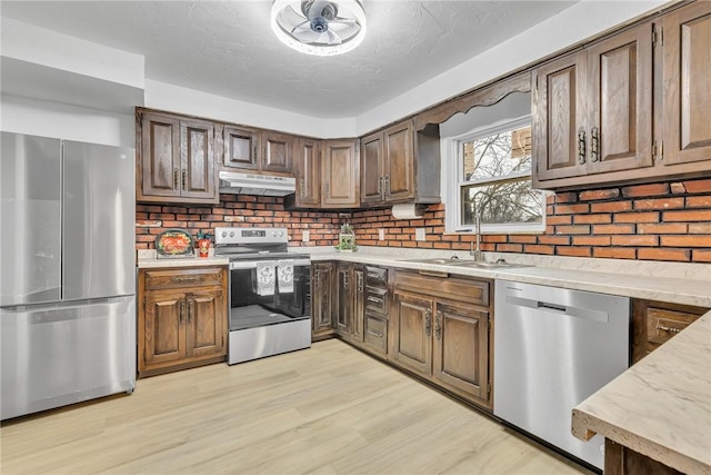 kitchen with stainless steel appliances, light hardwood / wood-style flooring, and sink