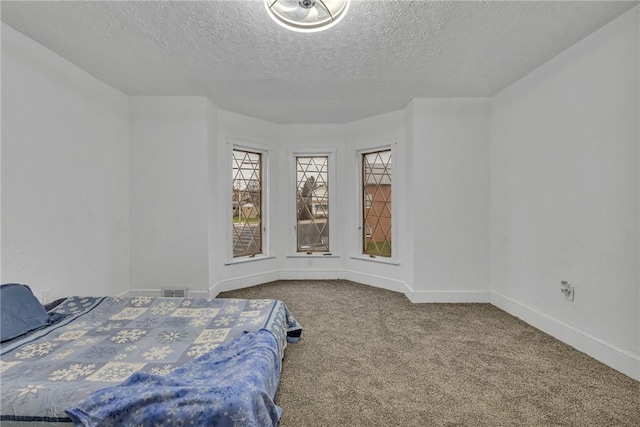 bedroom with a textured ceiling and carpet floors