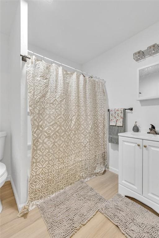 bathroom with hardwood / wood-style floors, toilet, and sink