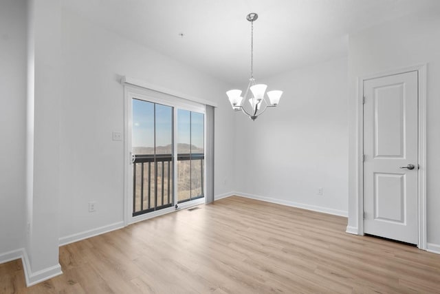 unfurnished dining area with light hardwood / wood-style flooring and a notable chandelier