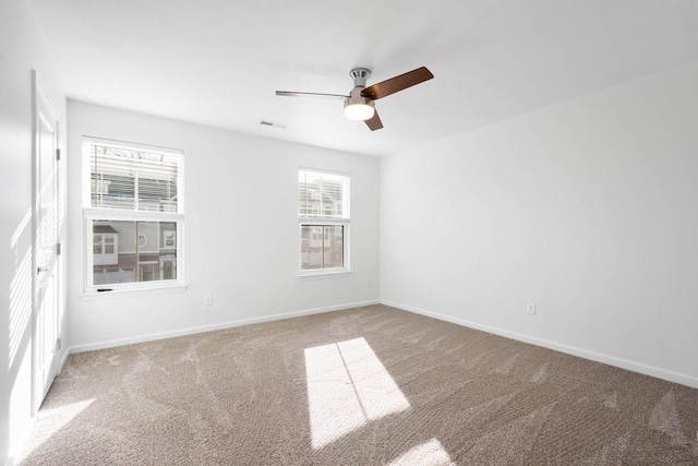 carpeted spare room featuring ceiling fan