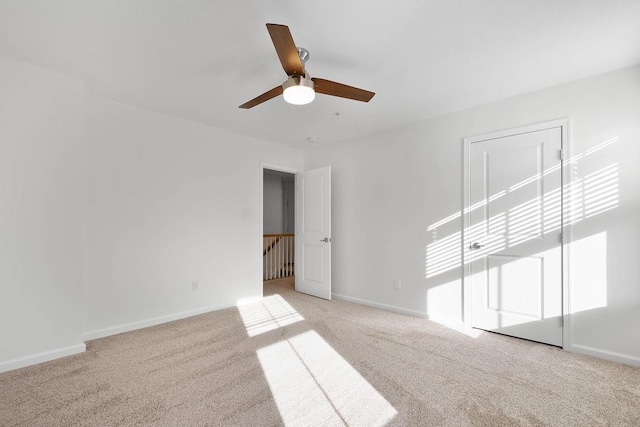 spare room featuring ceiling fan and light carpet