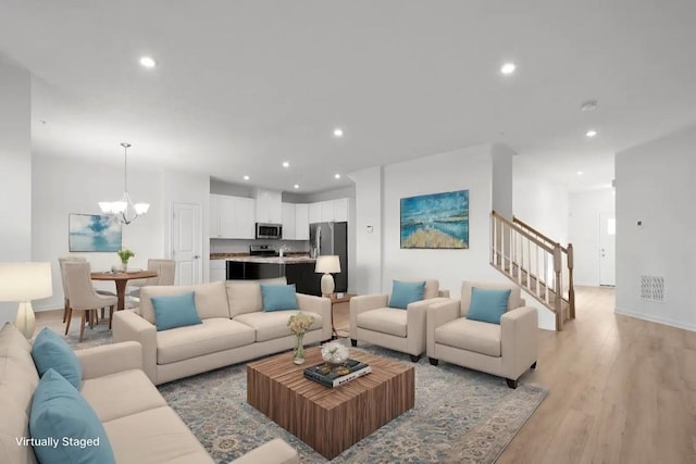 living room featuring light hardwood / wood-style floors and a notable chandelier