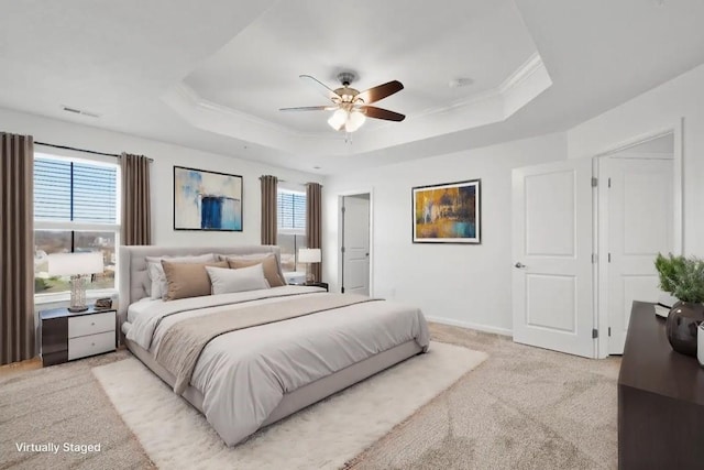 carpeted bedroom with multiple windows, a tray ceiling, ceiling fan, and crown molding