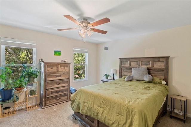 carpeted bedroom with multiple windows and ceiling fan