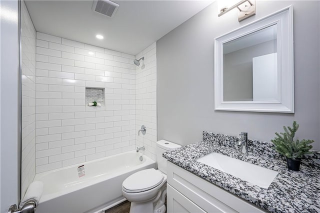 full bathroom featuring vanity, tiled shower / bath, and toilet